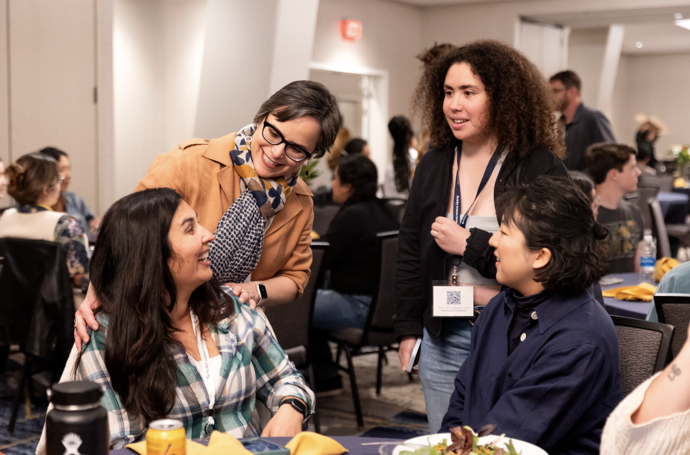 Lisa talking with students at a table.